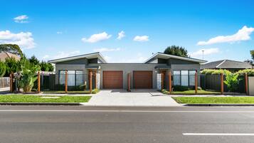 A modern two-story house with a garage, a driveway, and a well-maintained lawn.