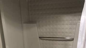 A modern bathroom with a bathtub, a shower, and a toilet.
