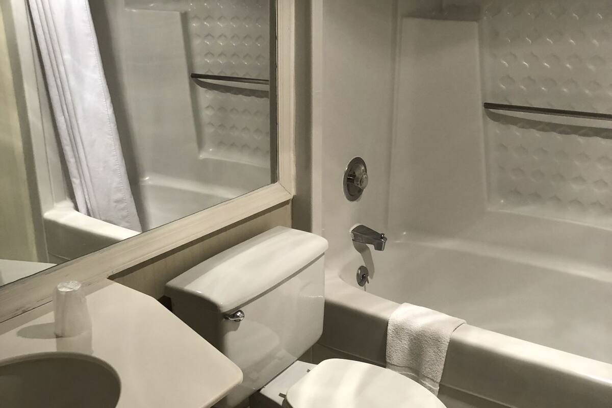 A bathroom with a toilet, sink, and bathtub.