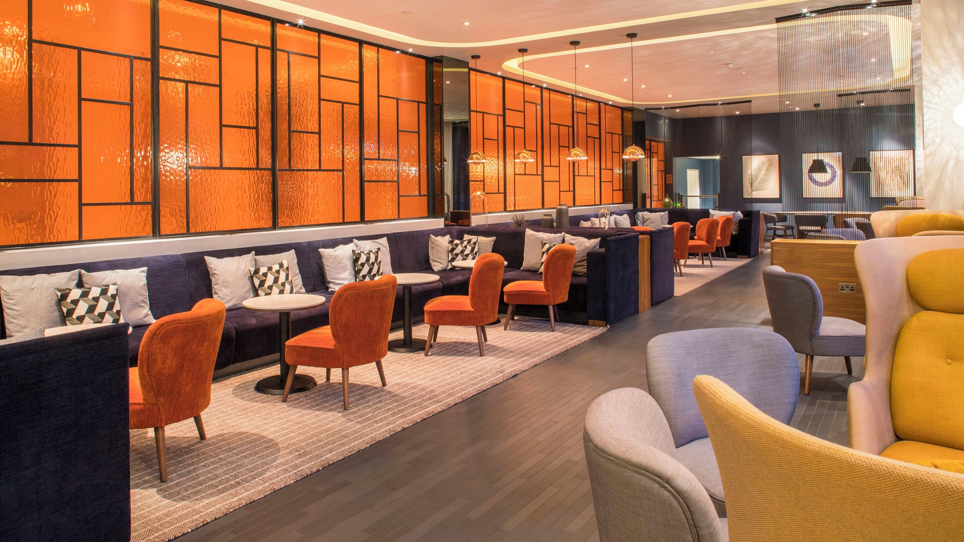 A modern lounge area with seating arrangements and a decorative wall.