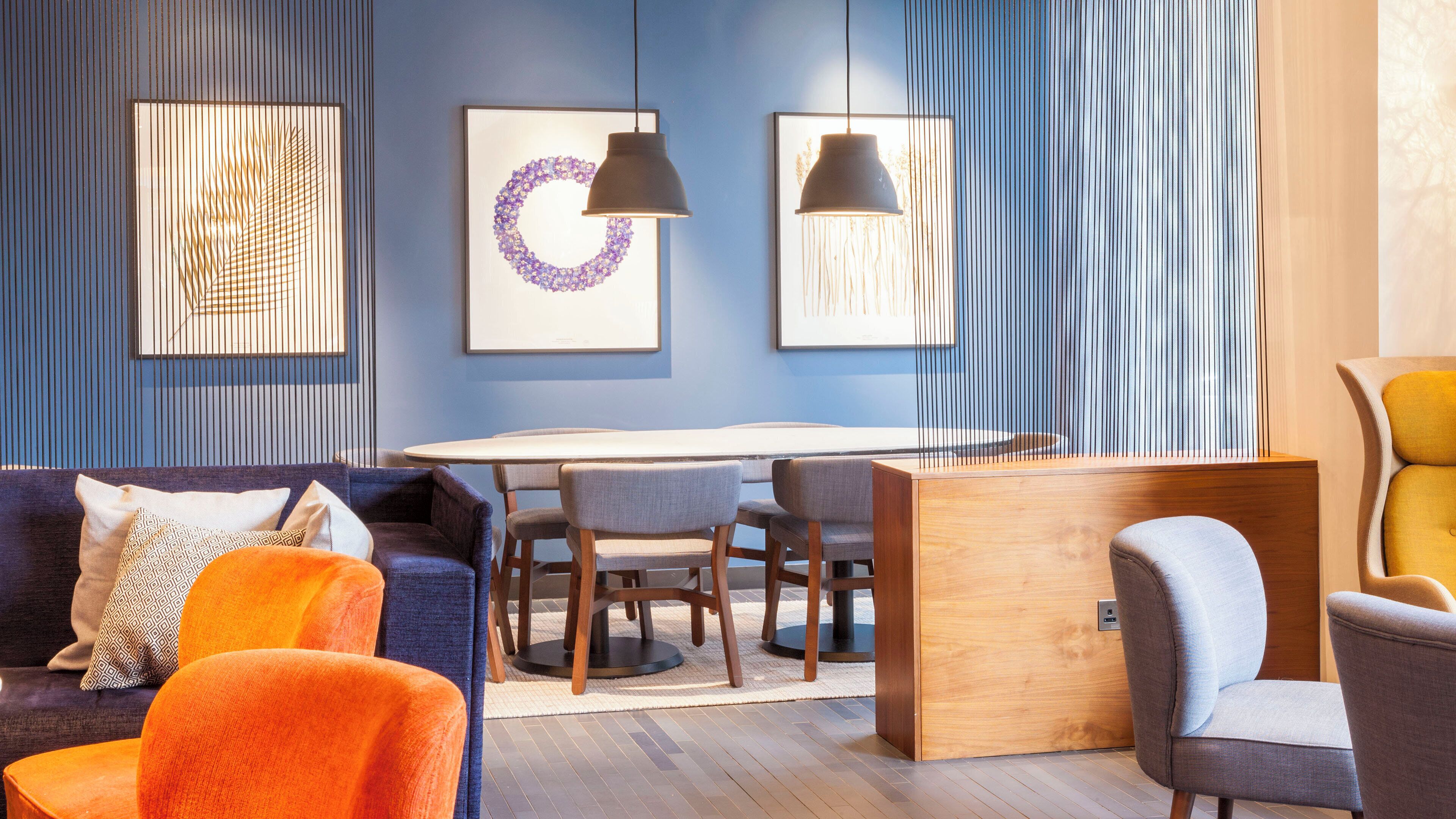 Et moderne interiør med spiseplads, sofaer og kunst på væggene.