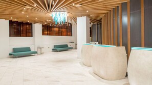 A modern lobby with a high ceiling, seating areas, and a reception desk. - Crowne Plaza London - Kings Cross by IHG (London)