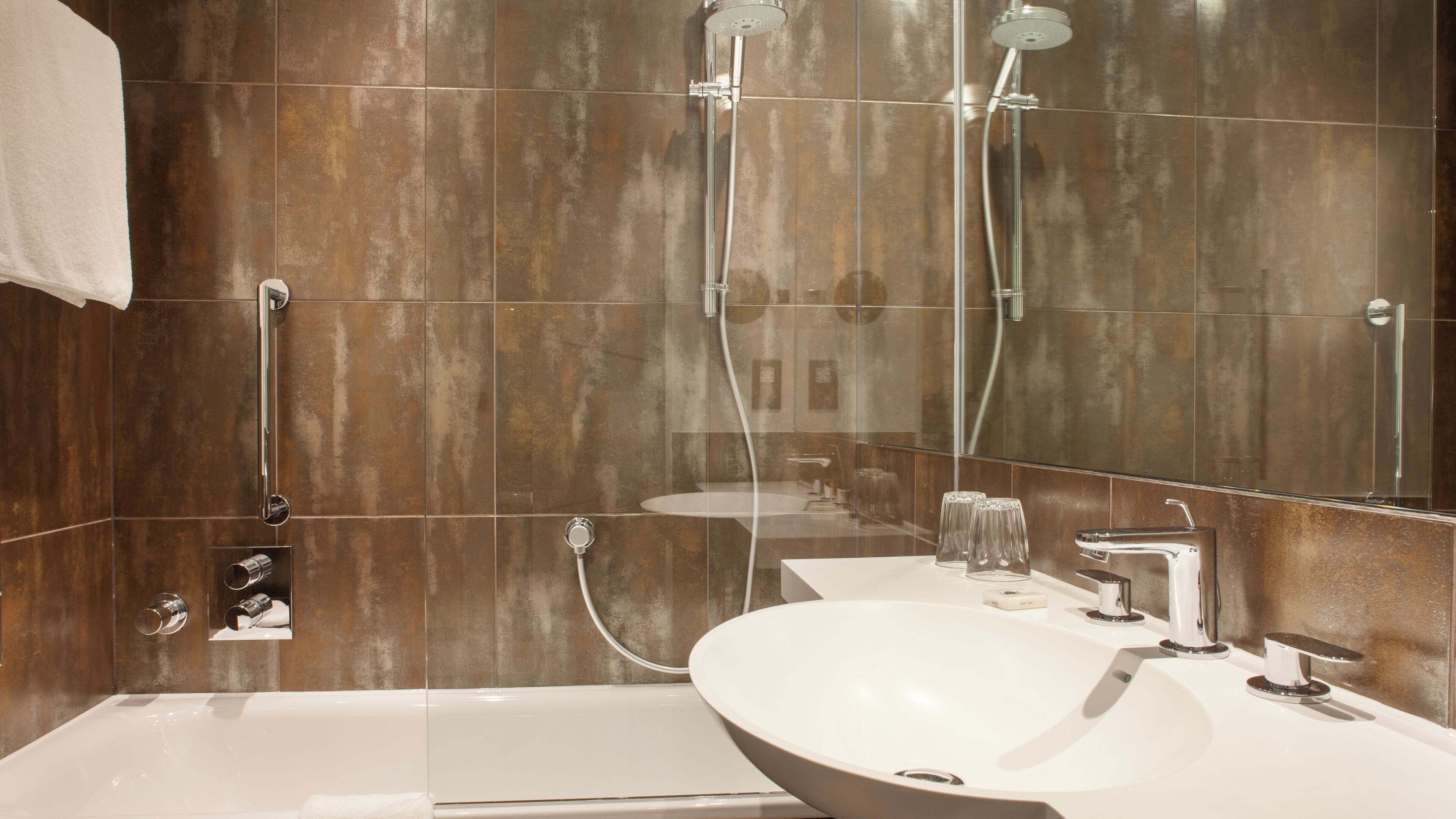 A modern bathroom with a large bathtub, a sink, and a shower area.