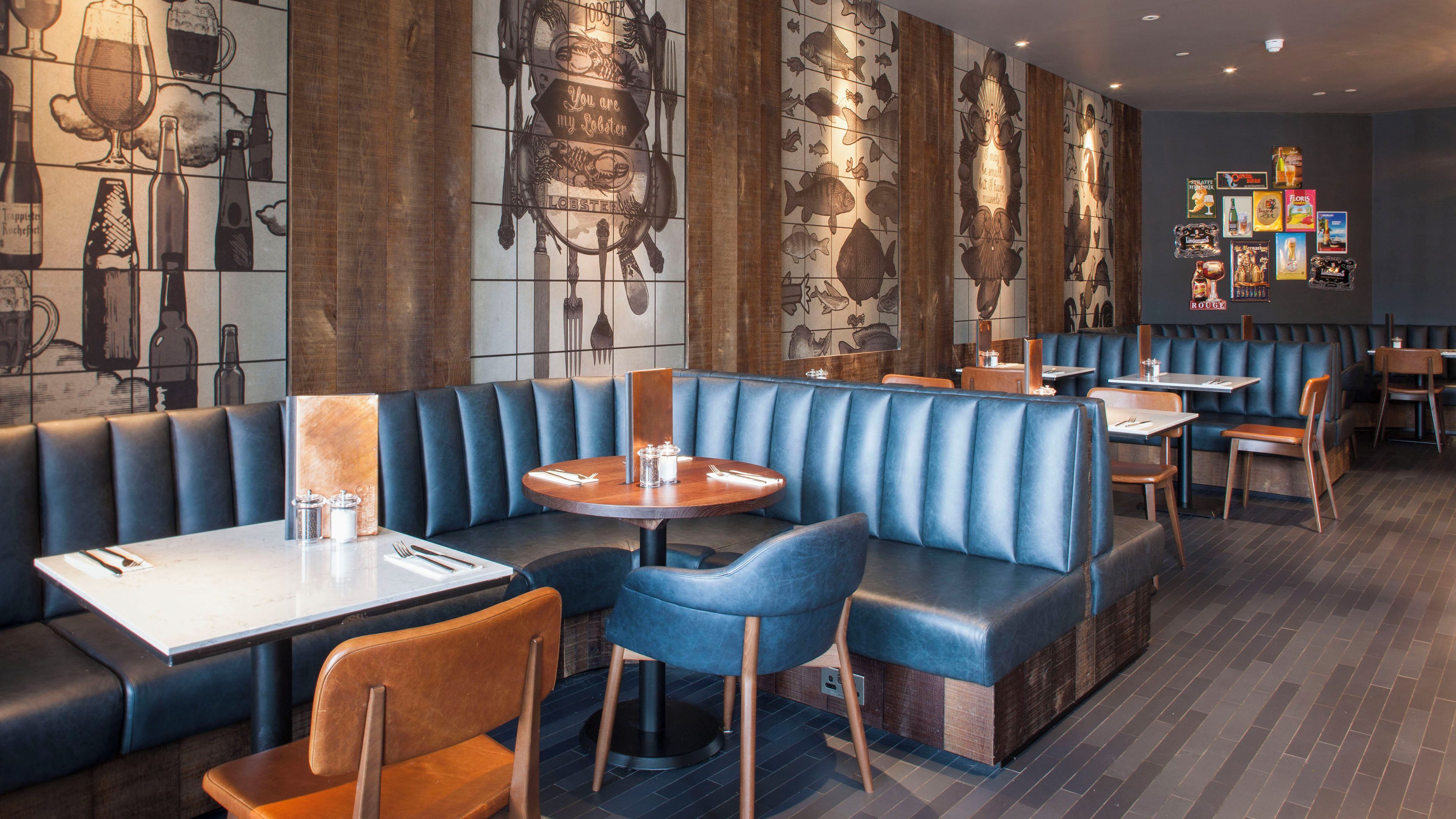 A restaurant interior with booths, tables, and a wall mural.