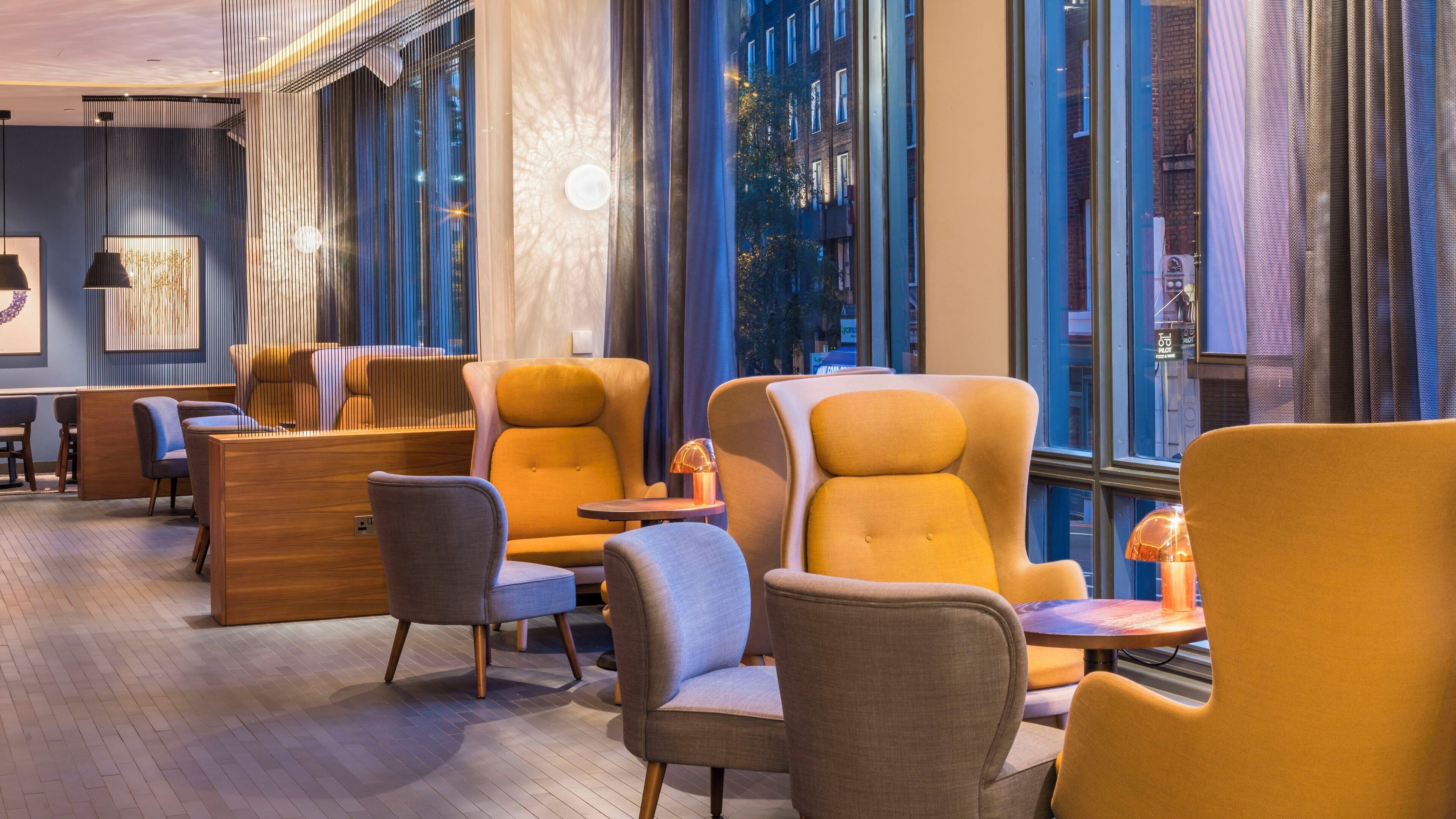 A modern interior with seating arrangements and large windows.