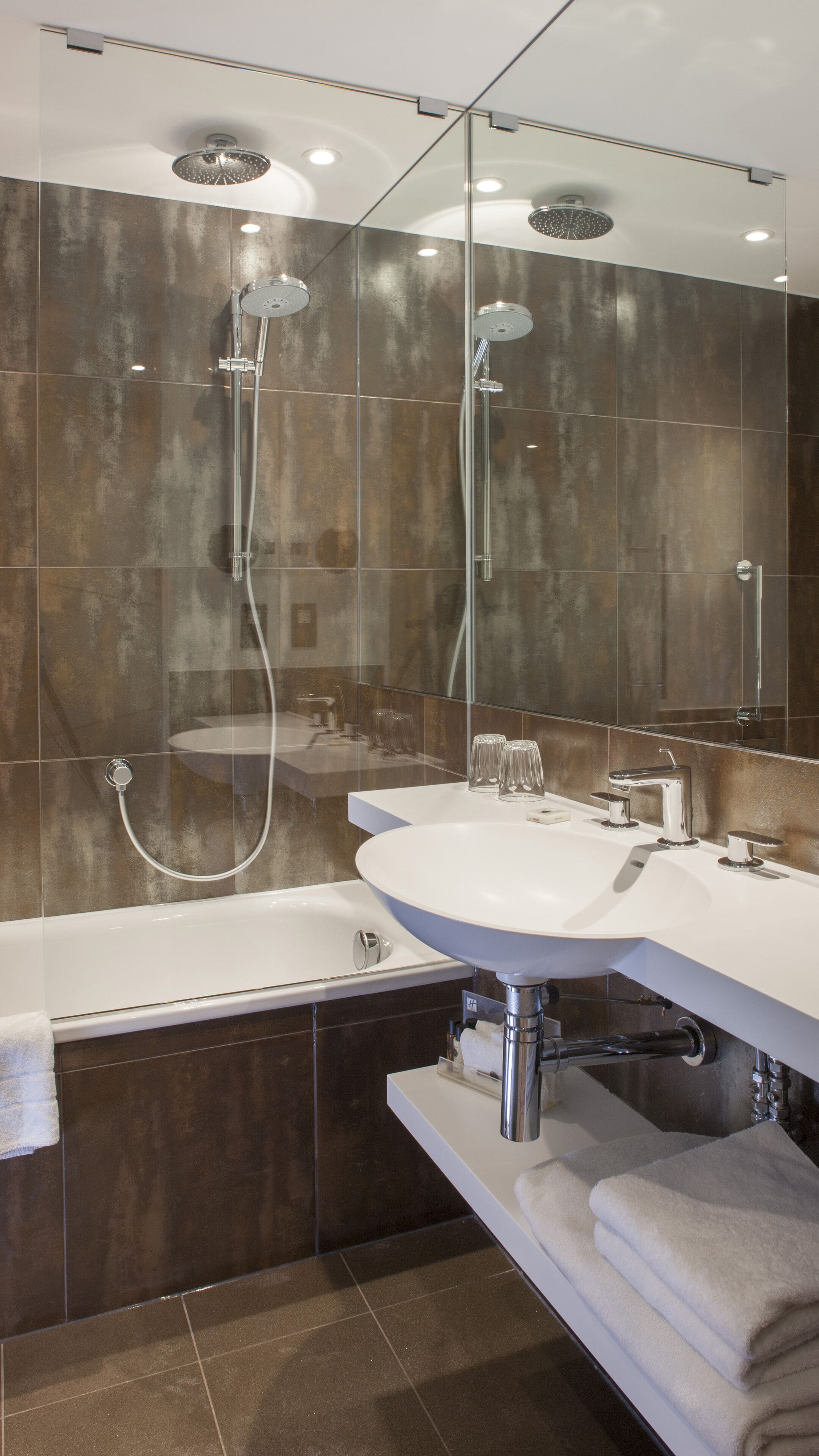 A modern bathroom with a glass-enclosed shower, a white sink, and a bathtub.