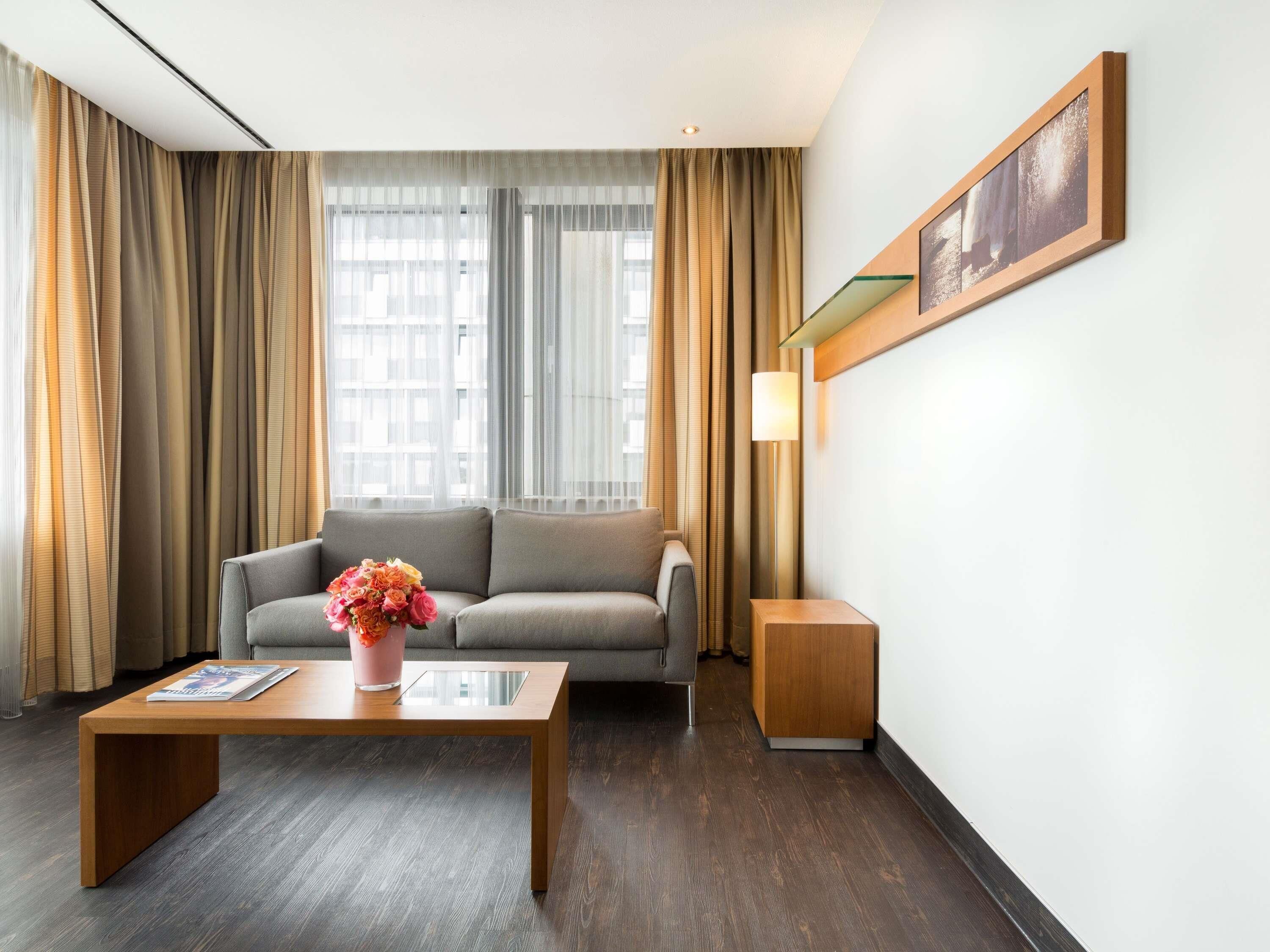 A modern living room with a sofa, a coffee table, a lamp, and a framed picture on the wall.