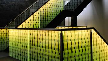 A staircase with glass railings and a patterned wall.