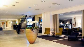 A hotel lobby with a large planter, seating area, and a staircase.