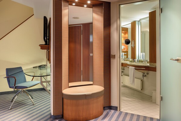 A modern bathroom with a wooden vanity, a glass shower enclosure, and a separate toilet area. - Sunday Hotel München Airport Freising (Freising)