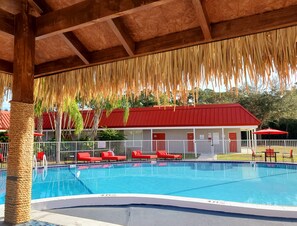 Una piscina al aire libre, sombrillas, tumbonas