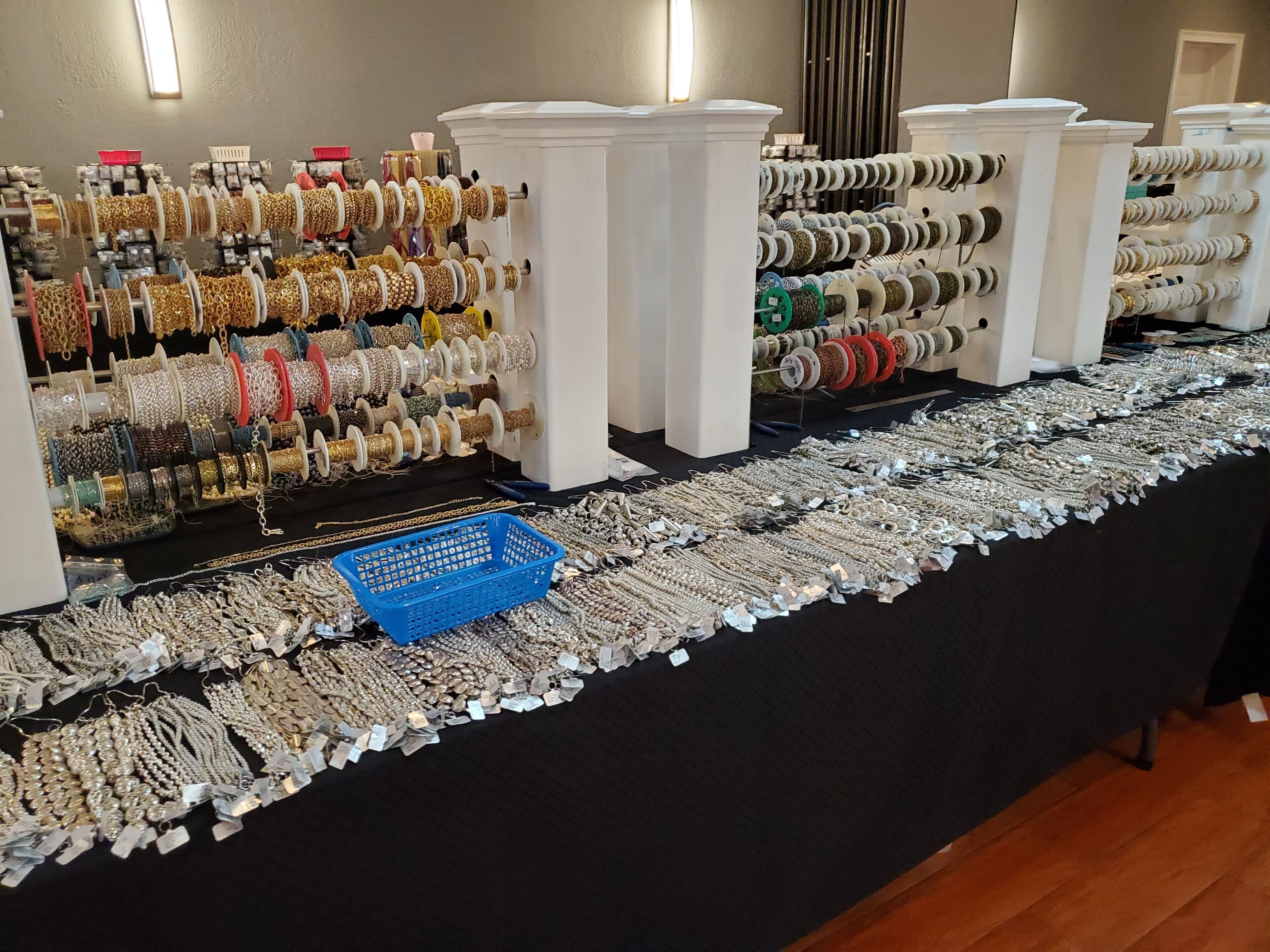 Una vitrina con varias pulseras y collares sobre estantes y mesas.