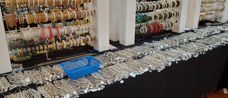 Una vitrina con varias pulseras y collares sobre estantes y mesas.