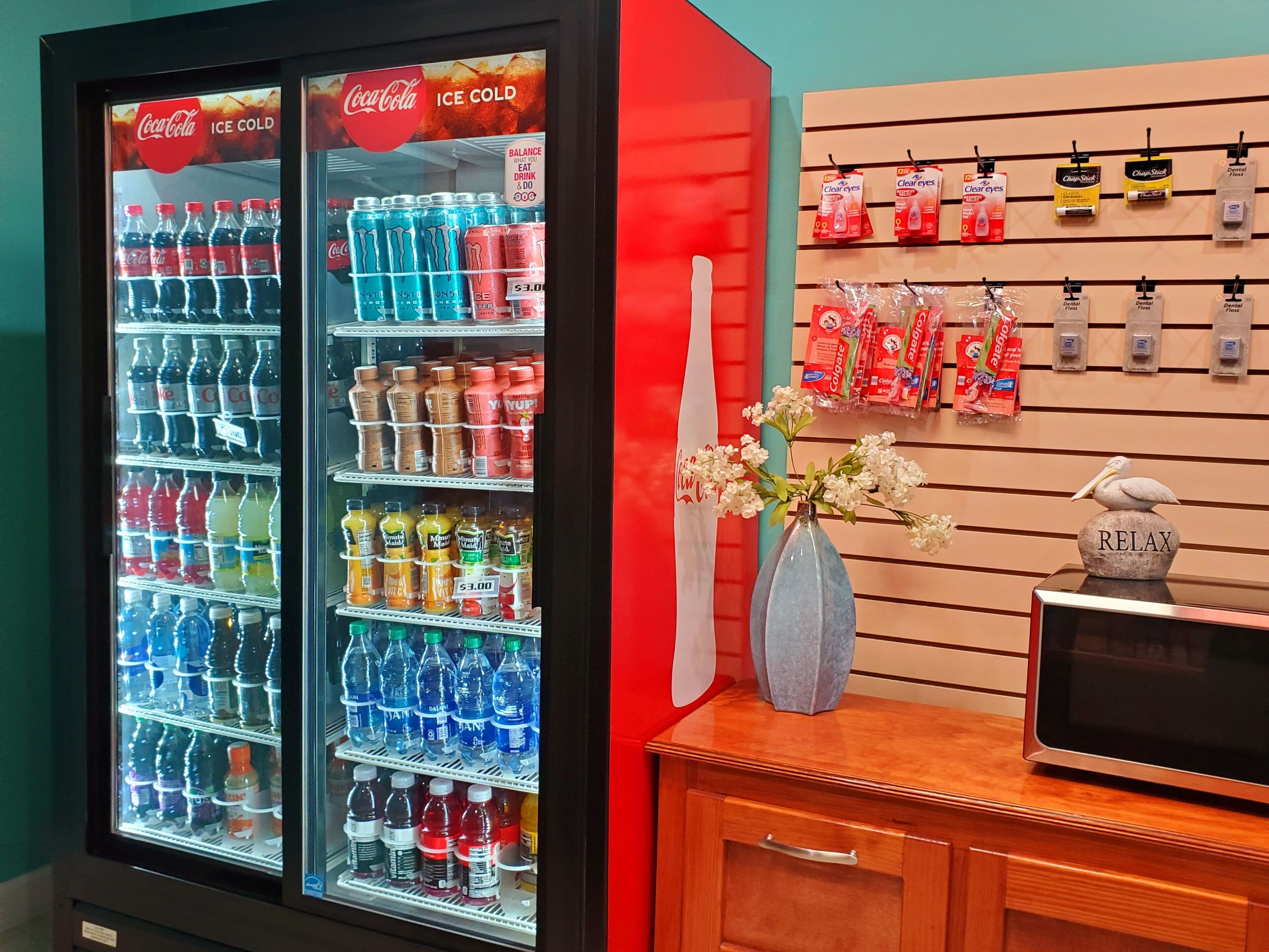 Máquina expendedora con diversas bebidas, hilo dental y otros productos para el cuidado bucal.