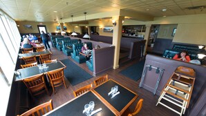 A restaurant with booths, tables, and a bar area. - Ramada by Wyndham Juneau (Juneau)