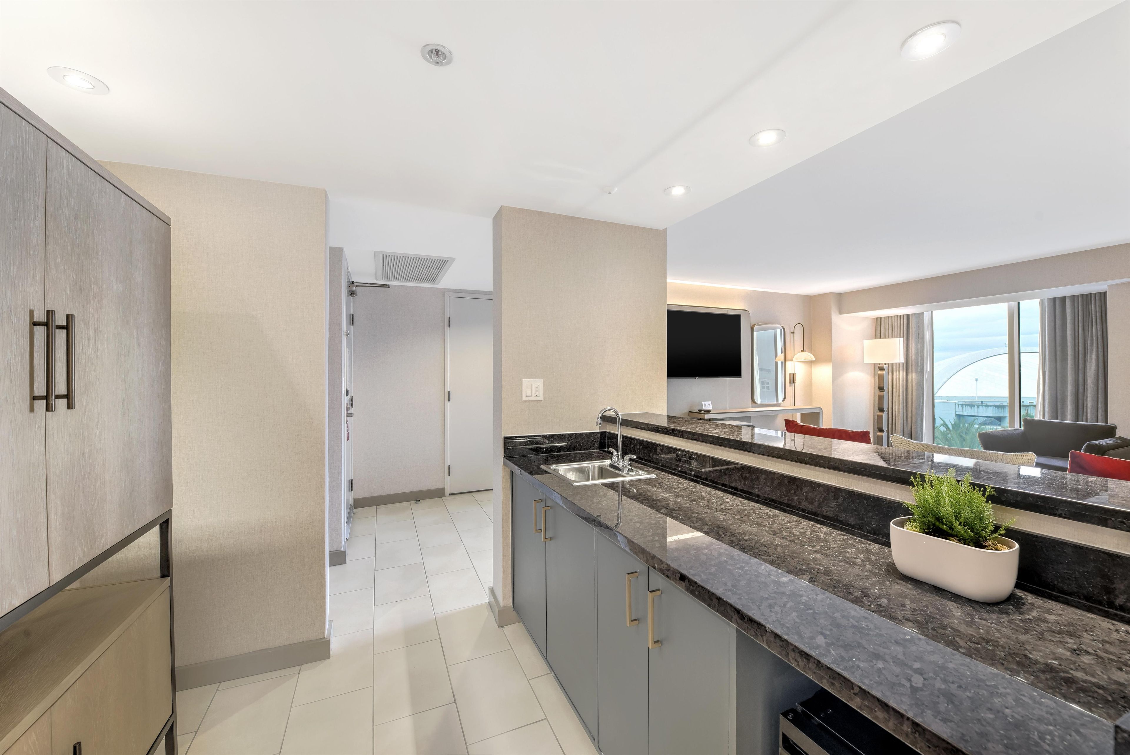 A modern kitchen with a large island, built-in appliances, and a view of the city.