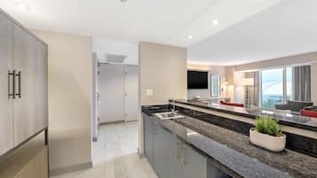 Una cocina moderna con una isla grande, electrodomésticos integrados y vistas a la ciudad.