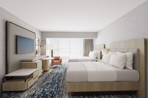 A hotel room with a large bed, a desk with a chair, a TV, and a window with curtains. - Hilton Anaheim (Anaheim)