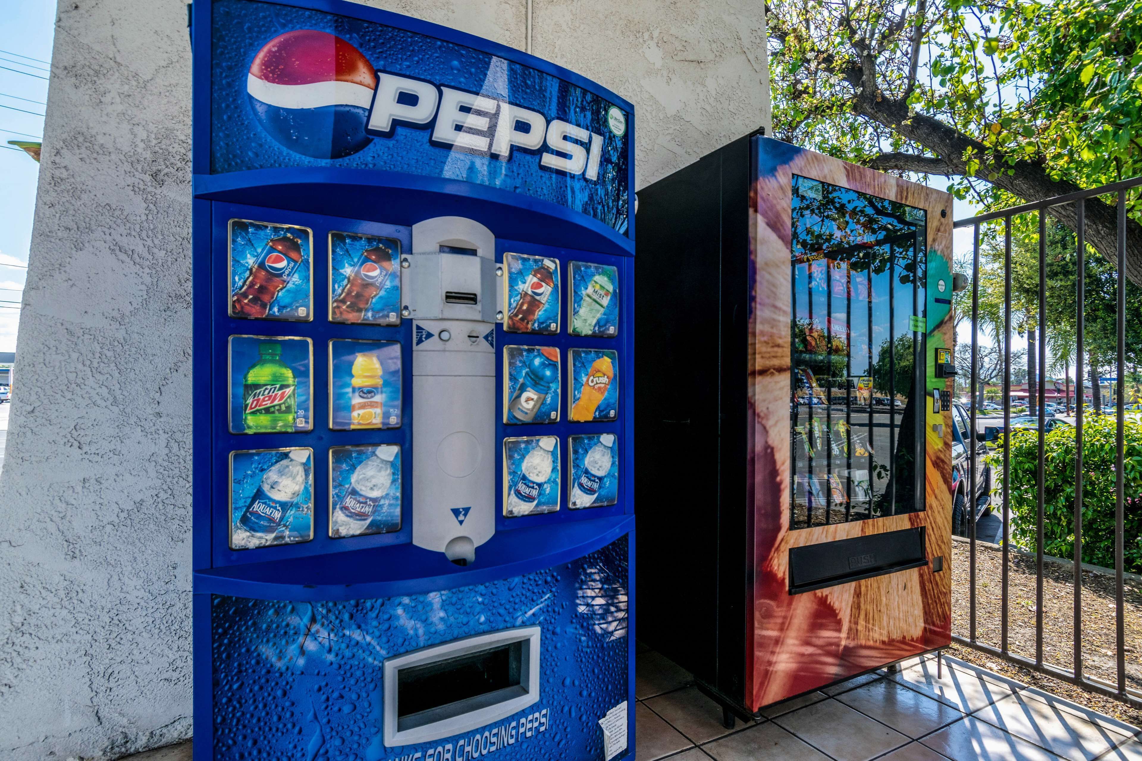 A blue Pepsi vending machine with various drink options and a payment slot.