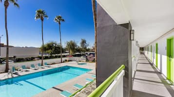 Una piscina al aire libre, sillones reclinables de piscina