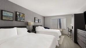 A hotel room with two beds, a desk, a chair, a TV, and artwork on the wall. - Revival Scottsdale Studios (Scottsdale)