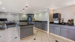 A modern kitchen with grey cabinets, a central island, and a built-in oven. - Revival Scottsdale Studios (Scottsdale)