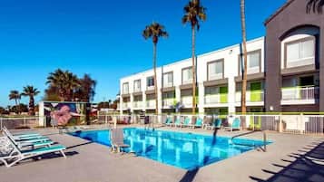 Una piscina al aire libre, sillones reclinables de piscina