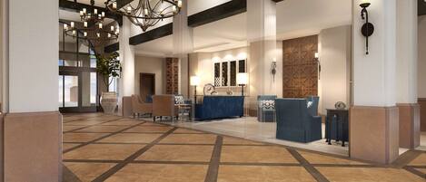 A spacious lobby with a large chandelier, seating area, and a reception desk.