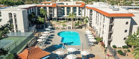 Ett hotell med pool, tennisbana och utsikt över bergen.