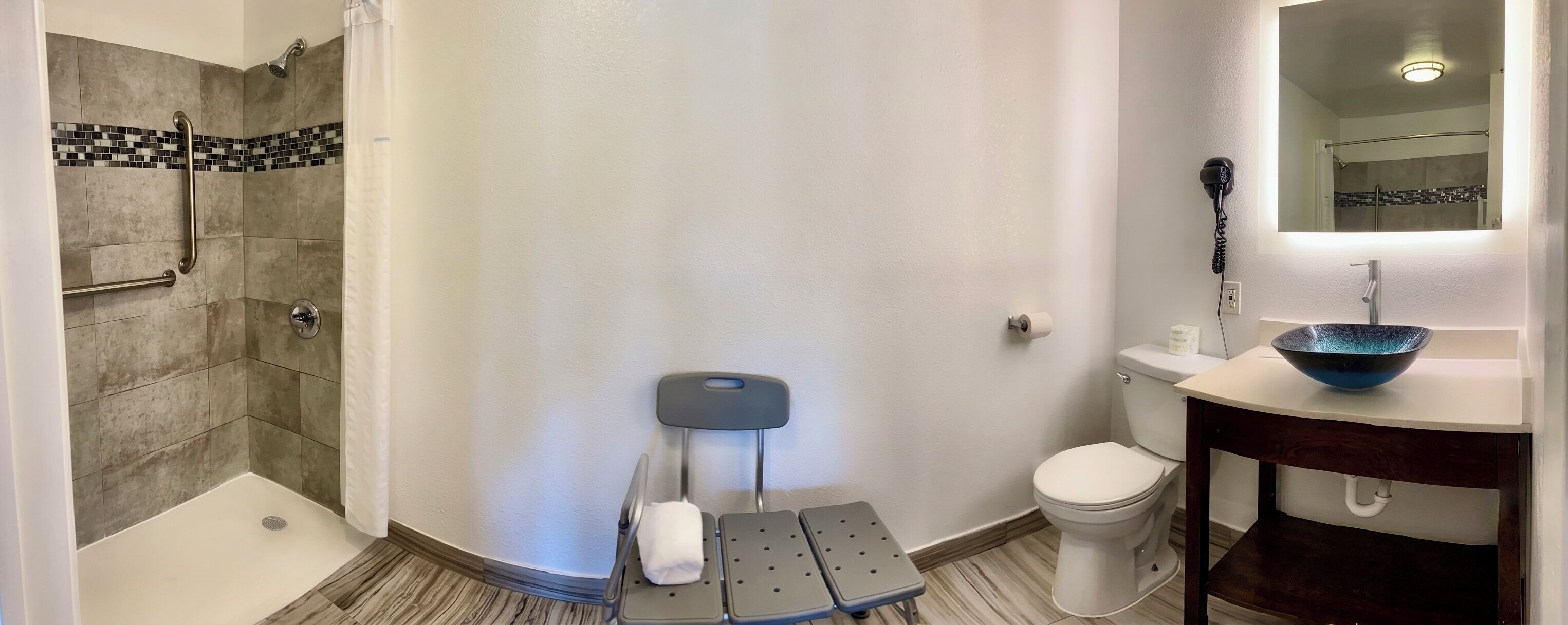 A bathroom with a shower, toilet, and sink.