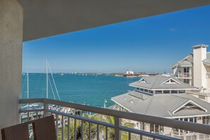 A balcony with a view of the sea, boats, and buildings.