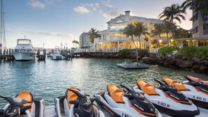 A marina with jet skis docked in front of a hotel with a dock and a boat in the background. - Hyatt Centric Key West Resort and Spa (Key West)