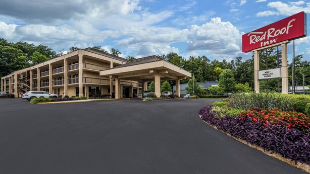 A Red Roof Inn with a large parking lot and a sign indicating newly renovated rooms. - Red Roof Inn Birmingham South (Birmingham)