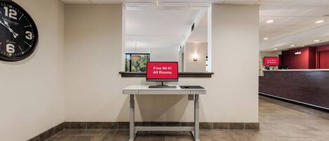 A reception desk with a sign indicating free Wi-Fi in all rooms.