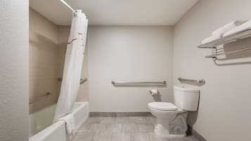 A bathroom with a bathtub, toilet, and shower curtain.