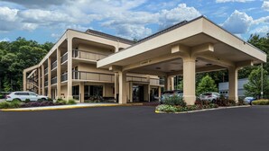 A multi-story hotel with a covered entrance and a parking lot. - Red Roof Inn Birmingham South (Birmingham)