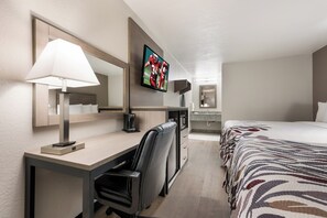 A hotel room with a desk, chair, bed, TV, and a coffee maker. - Red Roof Inn Birmingham South (Birmingham)