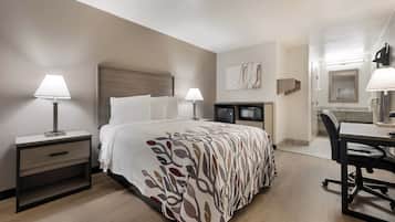 A hotel room with a bed, bedside tables, a desk, and a chair.