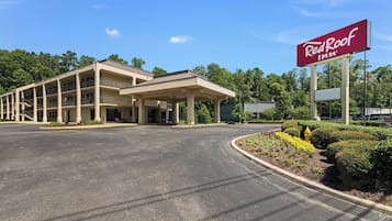 Un Red Roof Inn con parcheggio e un'area esterna coperta.