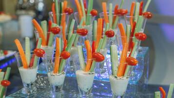 Un coin bar avec des verres contenant une boisson crémeuse, décorée de bâtonnets de carotte et de tomates cerises.