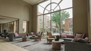 A spacious lobby with a large arched window, comfortable seating areas, and a modern interior design. - Courtyard by Marriott Nashua (Nashua)