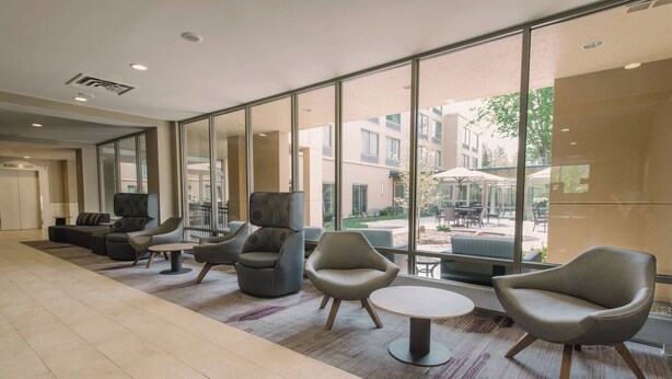 A spacious lobby with modern seating, large windows, and a view of the outdoor area. - Courtyard by Marriott Nashua (Nashua)