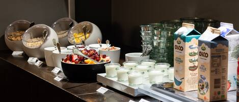 A breakfast buffet with various food items and milk cartons.
