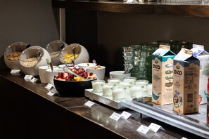 A breakfast buffet with various food items and milk cartons.