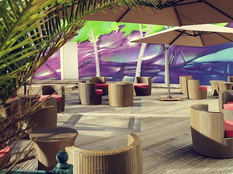 An outdoor seating area with wicker furniture and umbrellas.
