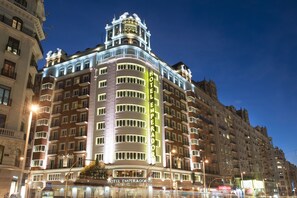 A multi-story hotel with a prominent "HOTEL EMPERADOR" sign, featuring a classic architectural style with balconies and large windows.