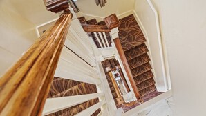 A staircase with wooden railings and patterned carpet. - Fitzgerald Hotel (San Francisco)