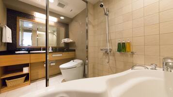 Un baño moderno con bañera, ducha con cerramiento de vidrio, inodoro y tocador con espejo.