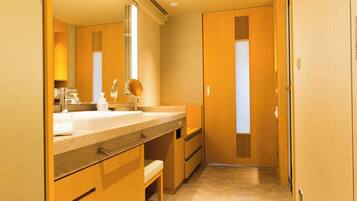 A modern bathroom with a large mirror, a sink, and a toilet.