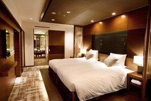 Relax in a spacious room with a large, neatly made bed and two bedside tables with lamps.